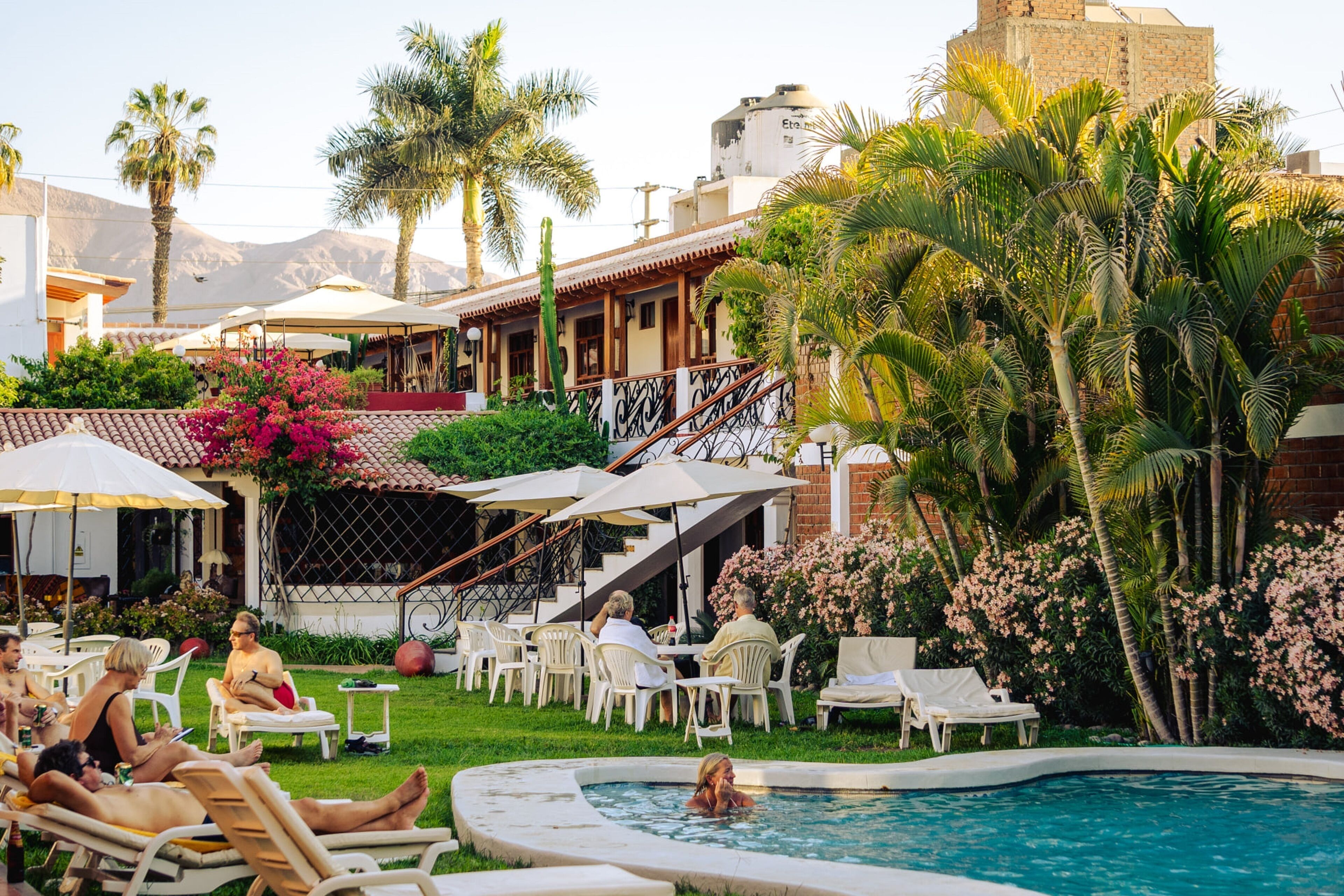 A poolside area with lounge chairs, a swimming pool, and a staircase leading to a building with a water tank on top.