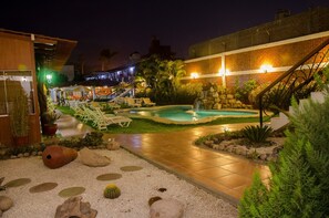 A nighttime outdoor pool area with lounge chairs, a small waterfall, and a well-lit patio. - Hotel Oro Viejo (Nazca)