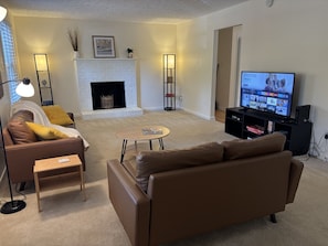 A living room with a fireplace, a sofa, a coffee table, and a TV.