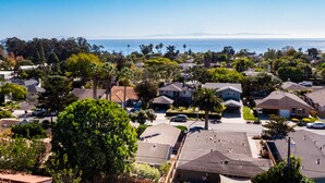 A residential area with houses, a clear view of the ocean, and a large tree in the foreground. - Two Bedroom Home Near Beach (Santa Barbara) (Santa Barbara)