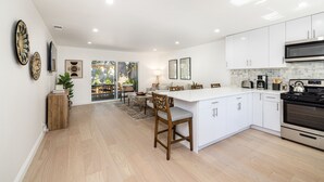 A modern kitchen with white cabinets, a large island, and stainless steel appliances. - Two Bedroom Home Near Beach (Santa Barbara) (Santa Barbara)