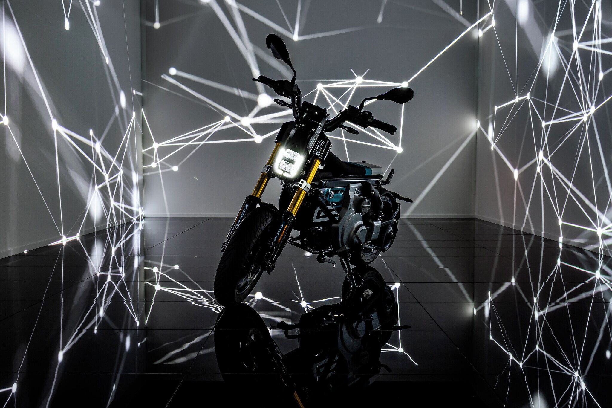 Une moto dans une pièce moderne dont le thème est basé sur des formes géométriques, avec un sol réfléchissant.