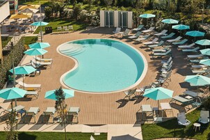 Een seizoensgebonden buitenzwembad, parasols voor strand/zwembad