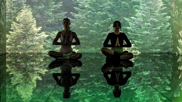 Two individuals seated in a meditative pose with a forest backdrop. - Quark Hotel Milano (Milan)