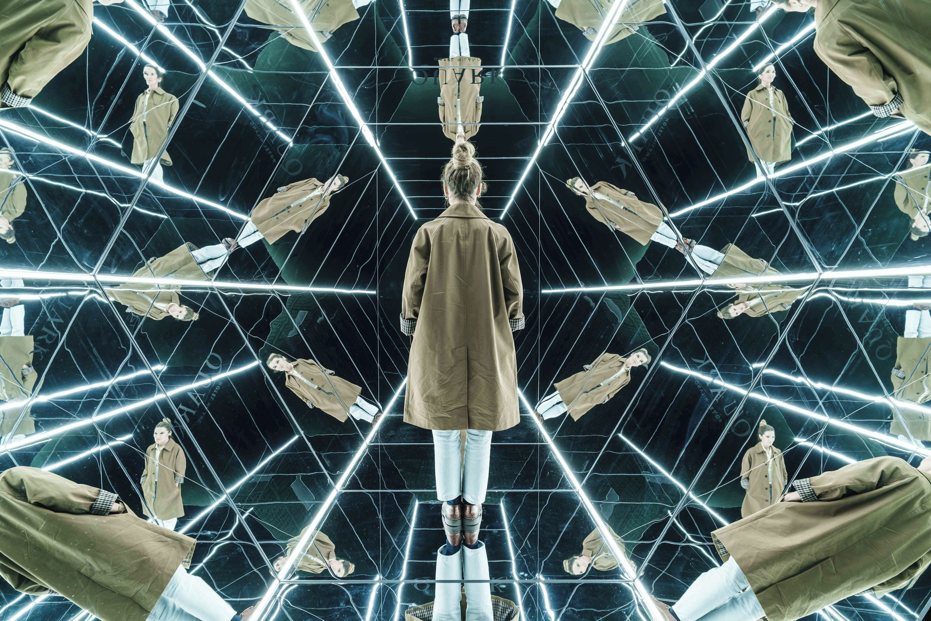 A symmetrical room with mirrored walls and a central figure.
