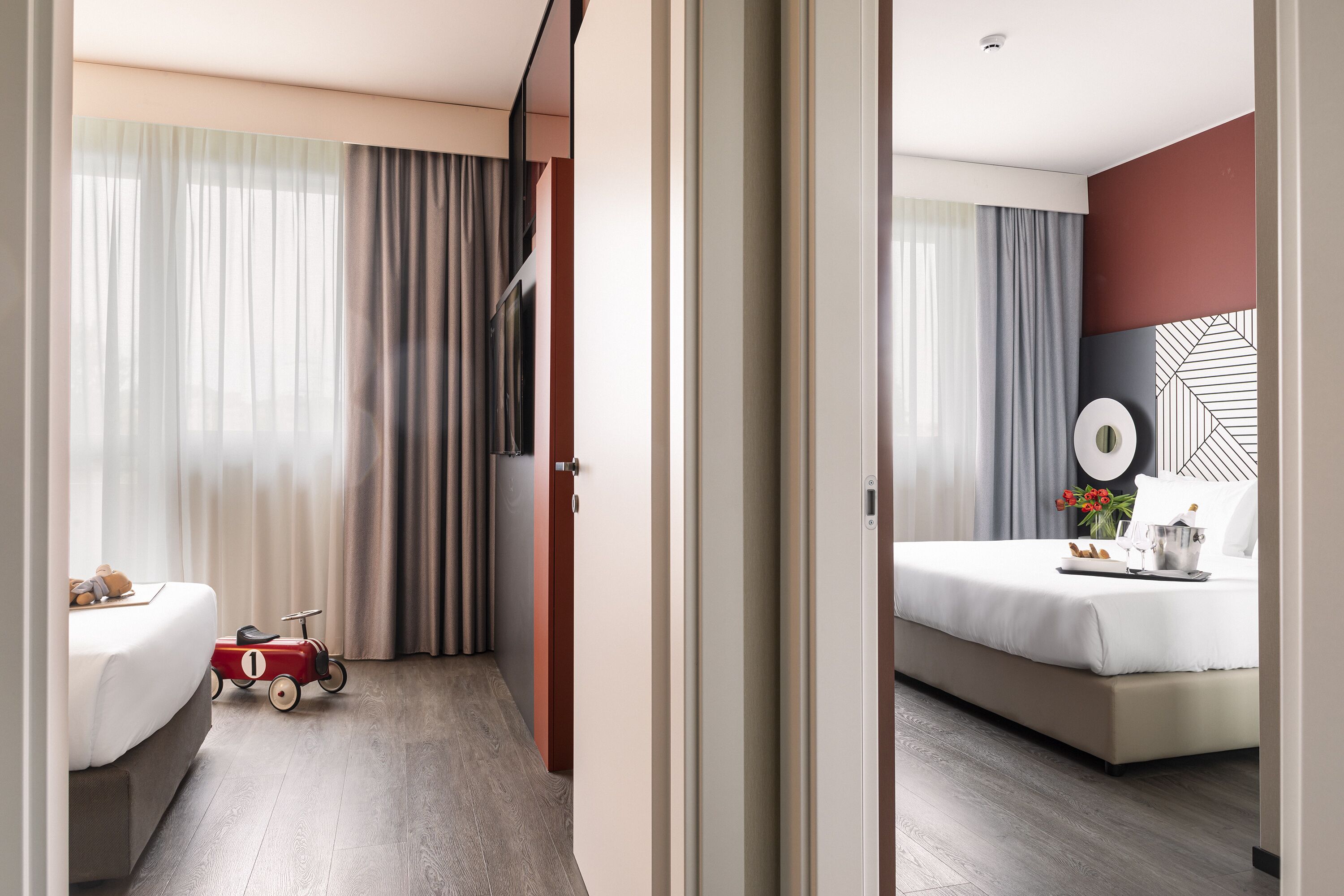 A hotel room with a bed, bedside table, and a toy car.