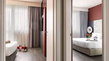 Una camera d'albergo con un letto, un comodino e una macchinina giocattolo.