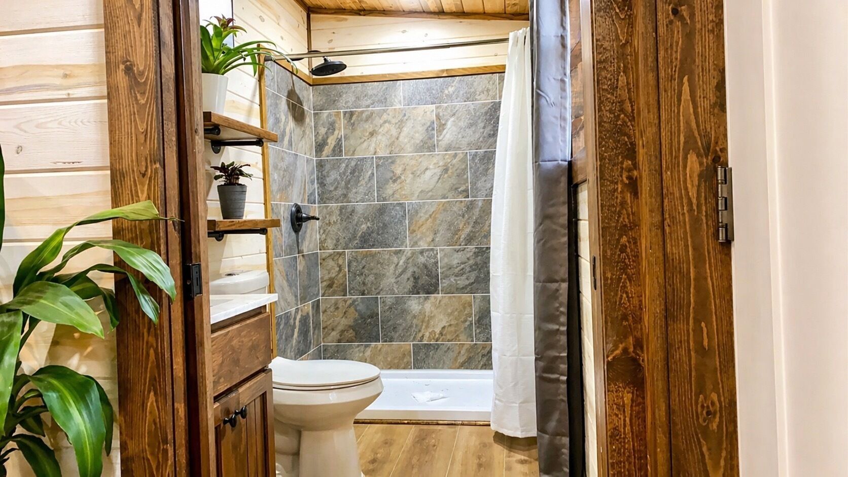 Un baño con inodoro, ducha y paredes de madera.