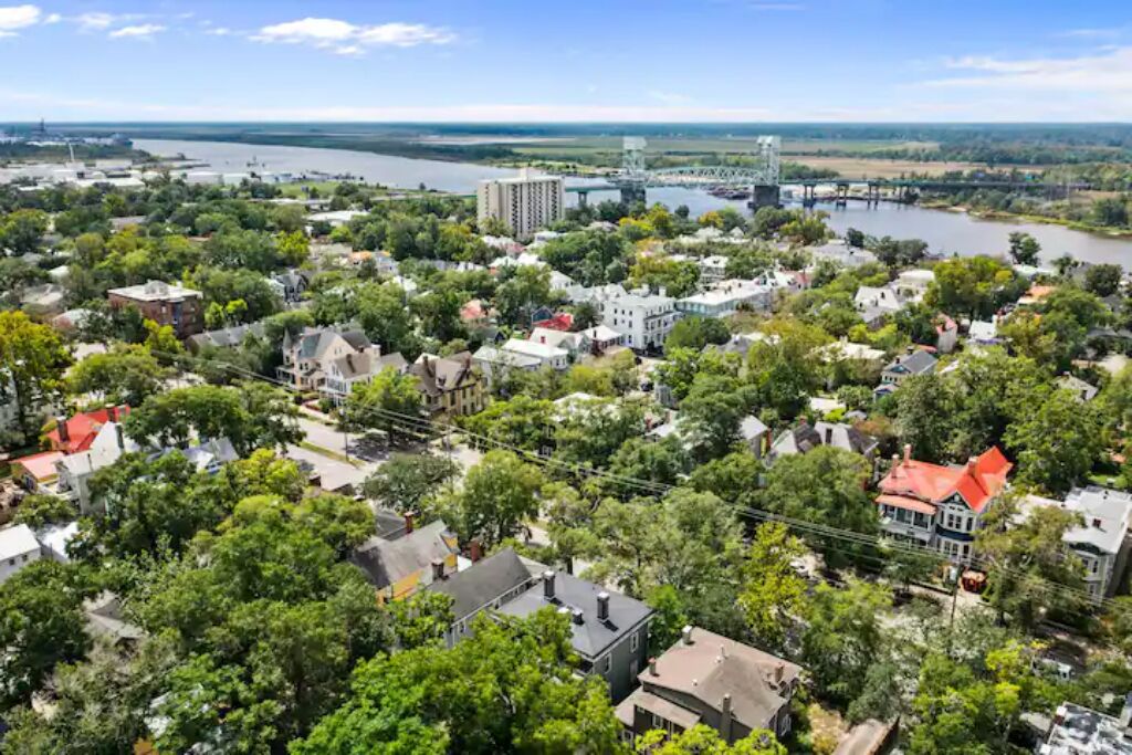 A residential area with houses, a river, and a bridge.