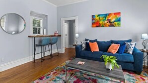 Un salon moderne avec un canapé bleu, une table basse et un tapis aux couleurs vives.