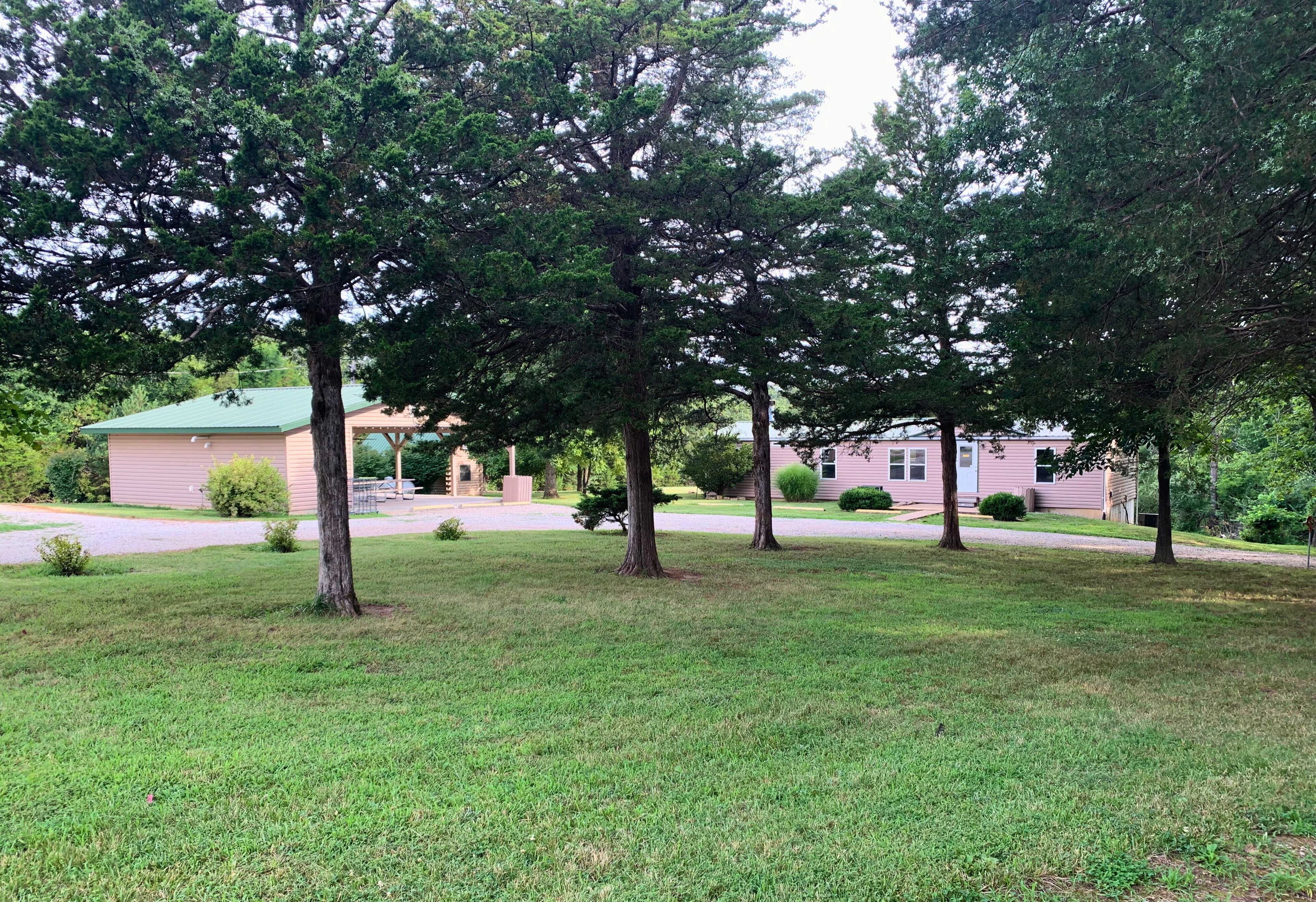 Zona residencial con una casa, un camino de entrada y varios árboles.