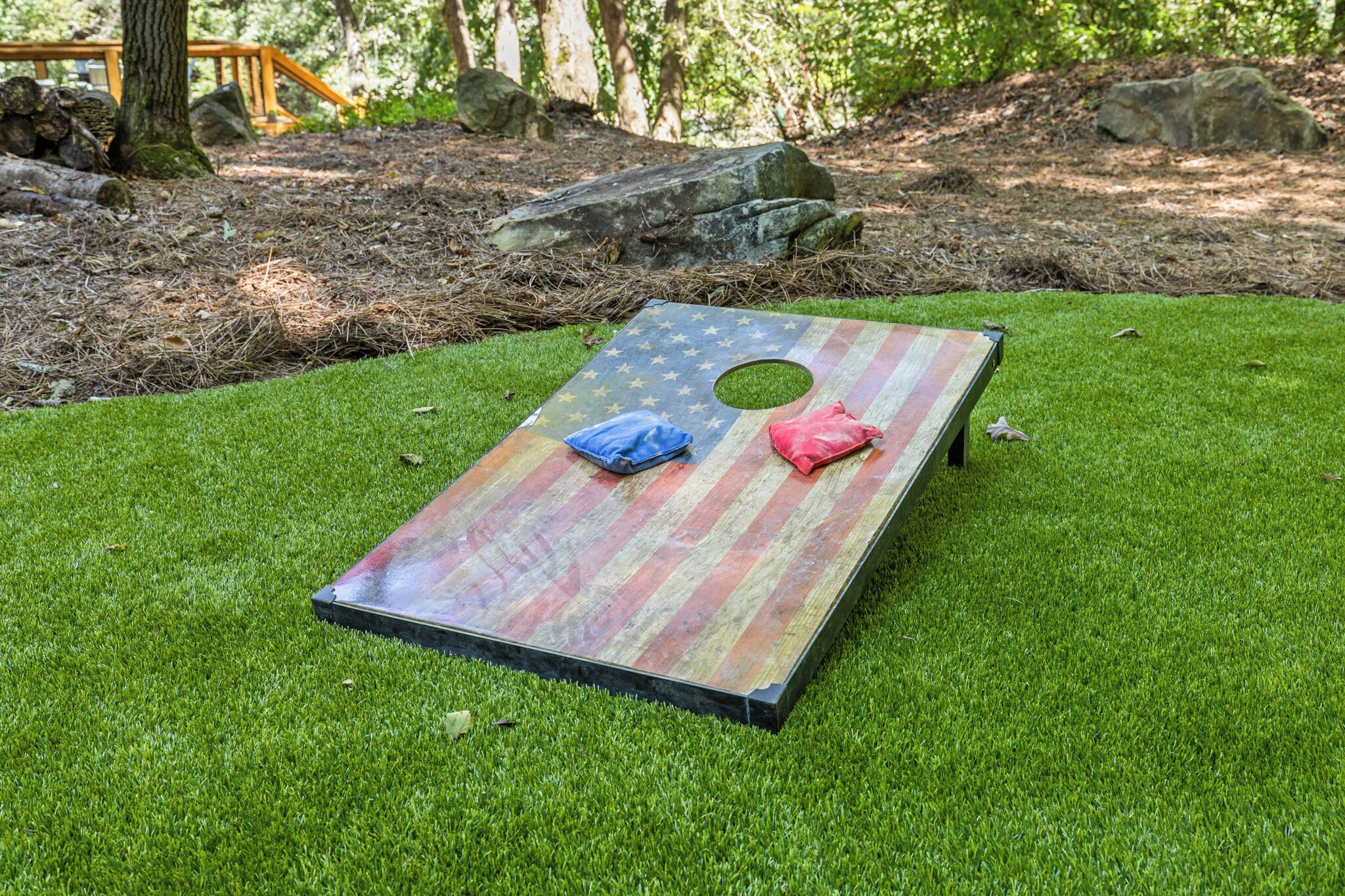 Une surface plane ornée d’un motif en étoile et percée de deux trous, le tout entouré d’herbe.