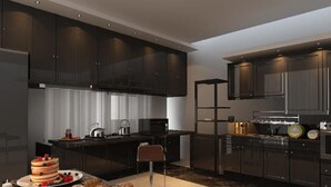 Een moderne keuken met donkere kasten, een centraal eiland en een ontbijtgedeekte eethoek.
