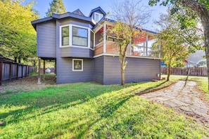 A two-story house with a sloped roof, a covered porch, and a fenced backyard.