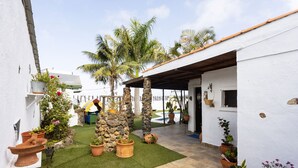 A courtyard with artificial grass, potted plants, and a stone pillar. - Casa Cateyma with pool (Icod de los Vinos)