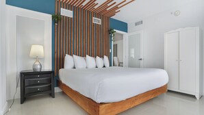 Une chambre moderne avec un cadre de lit en bois, une literie blanche, une table de chevet avec une lampe et un panneau mural à rayures.