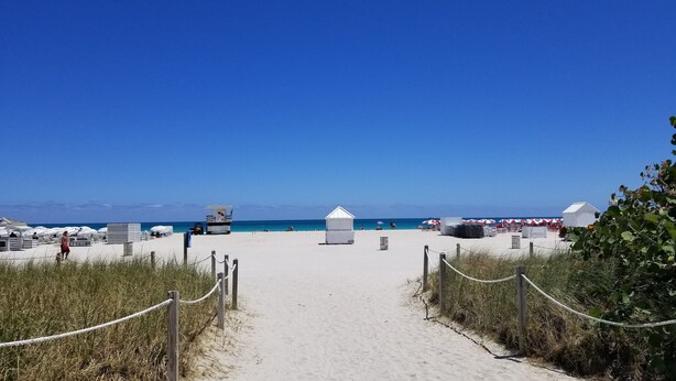 A beach pathway leading to a lifeguard station and beach umbrellas. - NEW LISTING! Premium 2 bedroom/2bathroom Sleeps 7 (Miami)