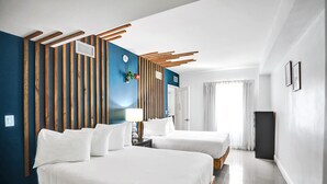 Een hotelkamer met twee bedden, een wand van houten latten, een klok en een televisie.