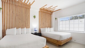 Un dormitorio moderno con dos camas, cabeceros de listones de madera, una mesita de noche con lámpara y una ventana con persianas.