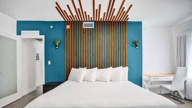 Une chambre d’hôtel moderne, dotée d’un grand lit, d’un bureau et d’une chaise.