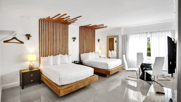Ein modernes Hotelzimmer mit zwei Betten, einem Schreibtisch und einem Stuhl.