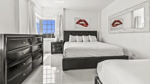 A modern bedroom with a large bed, a dresser, and two bedside tables.