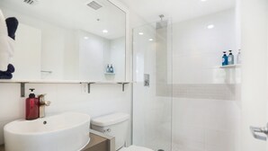A modern bathroom with a white sink, toilet, and glass-enclosed shower. - NEW LISTING! Belleza Sobe Private Entrance studio Sleeps 4 (Miami)