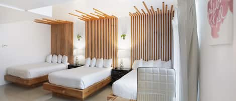 A modern hotel room with two beds, a glass table, and a wooden partition.