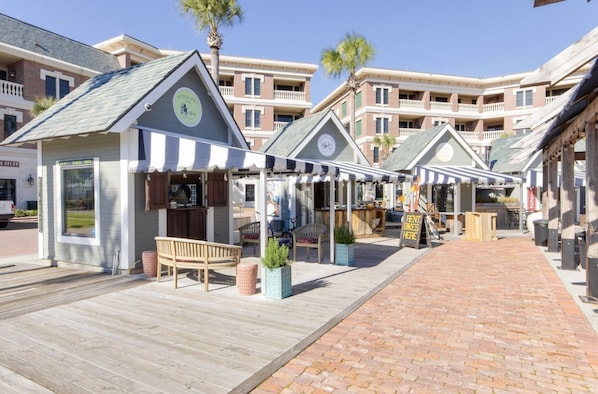 A boardwalk with outdoor seating and a rental bike sign.