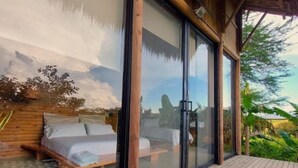 Una terraza de madera con una cama y una silla de descanso.