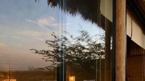 Una habitación moderna con dos camas, una pared de cristal y vistas al exterior.