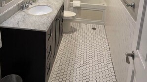 Een kleine badkamer met wastafel, toilet en douche.