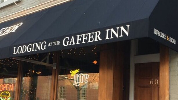 The exterior of the Gaffer Inn, featuring a black awning with the name and a neon sign for a nearby burger joint. - Double Queen Guestroom (Corning)