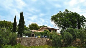 A stone wall with a pool area, a house with a tiled roof, and surrounding greenery. - Villa Il Casolare Country House With Pool on Sperlonga's Hill (Itri)