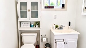 Ein Badezimmer mit Toilette, Waschbecken, Schrank und einer blauen Fußmatte.