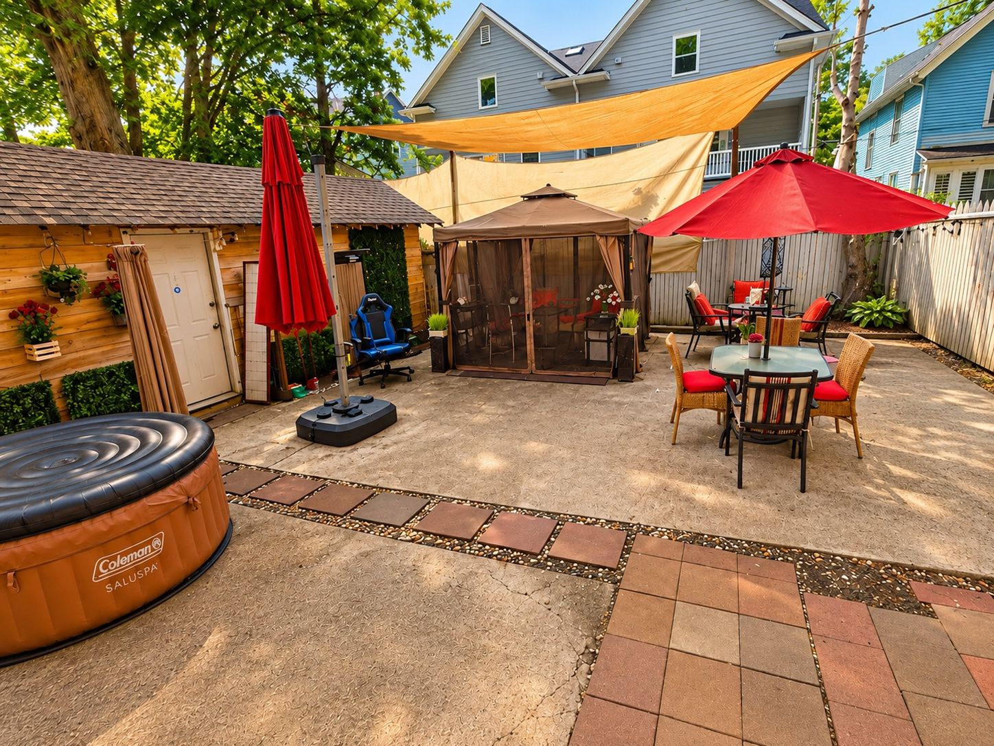 A backyard patio with a Coleman hot tub, outdoor seating, and a covered area.