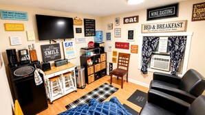Ein kompakter Wohnbereich mit Küchenzeile, Essbereich, Sitzecke mit Sofa und Wand-Fernseher.