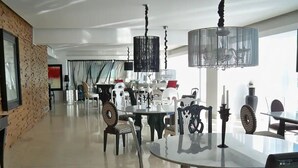 Zona menjador àmplia amb un llum central modern, una finestra gran i una paret d'accent de maó.