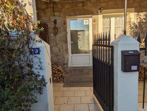 Ein Gebäude aus Stein mit einem Metalleisen, einer Tür mit Fenster und einem Schild, das auf ein Pub hinweist.