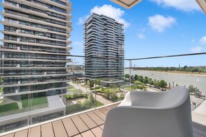 A modern high-rise building with multiple balconies, a view of a river, and a clear sky. - Belgrade Waterfront Riverside Apartments (Belgrade)