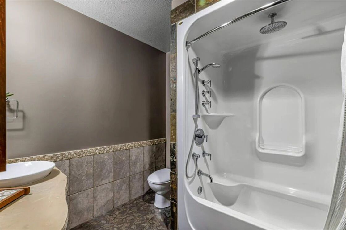 Een badkamer met een bad, toilet en wastafel.