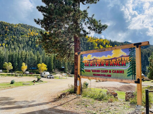 A campground sign with a mountain backdrop.