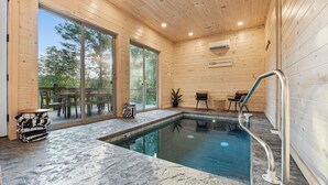 An indoor swimming pool with wooden walls and large windows. - NEW Luxury Cabin, Lake and Mountain Views/ Easy Access to Pigeon Forge! (Sevierville)