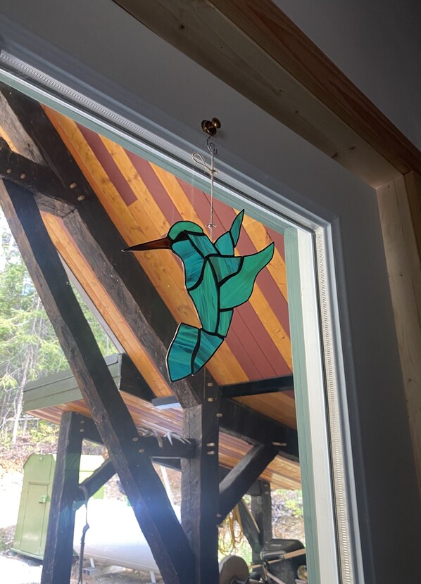 A stained glass window with a bird design. - Hummingbird Haven Charming Cabin in the Mountains (Golden)