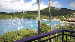 A coastal view with boats, palm trees, and a mountainous backdrop. - This exceptional property offers the convenience of being just a short stroll from Cruz Bay, all while providing the comfort of full air conditioning. Don't miss out on this perfect blend of location and luxury! (St John)