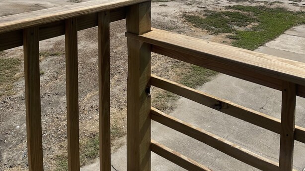 A wooden deck overlooking a beach with a clear sky and distant shoreline. - Lovely Beach View, 2 BR Condo (Corpus Christi)