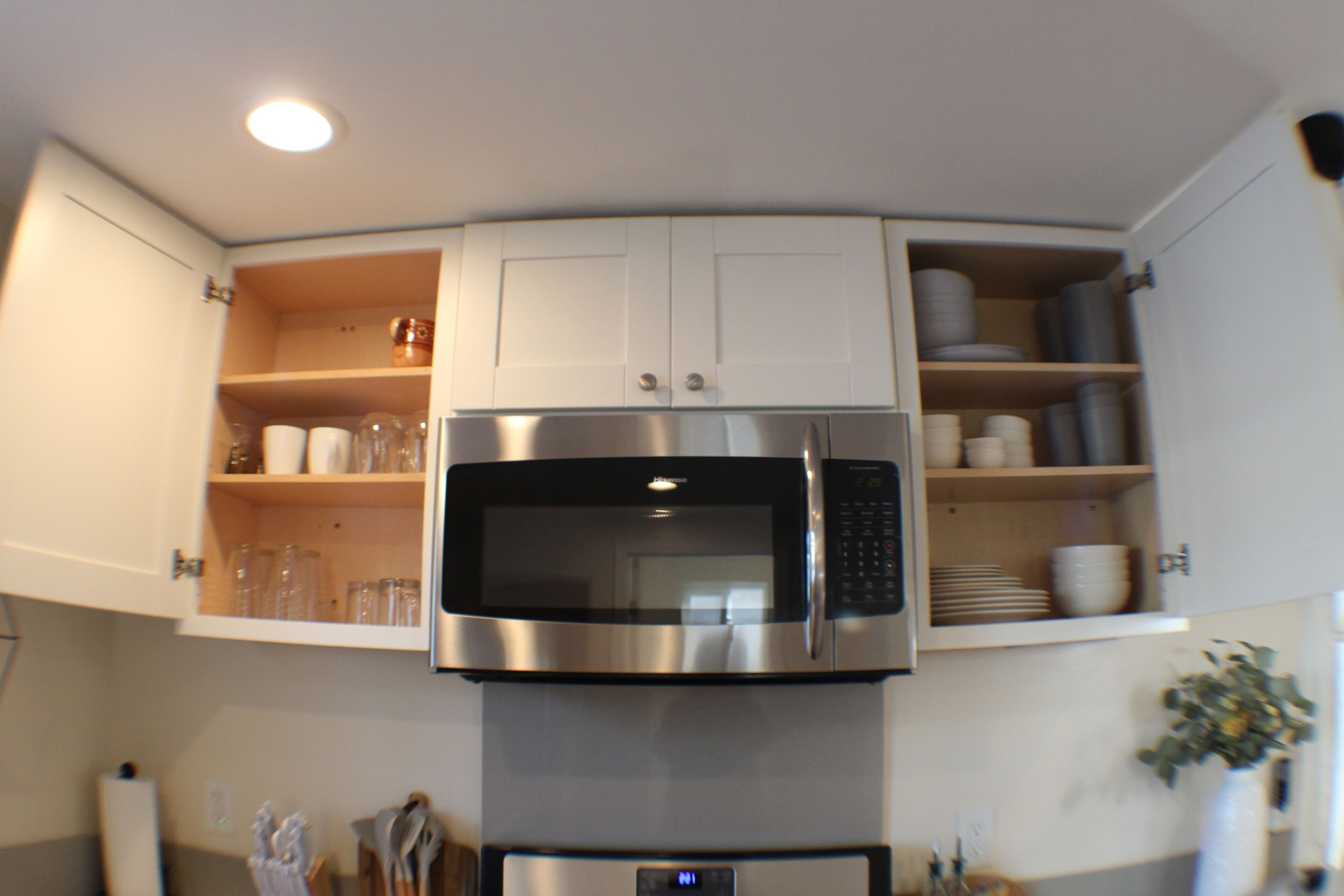 A kitchen with a built-in microwave and a refrigerator.