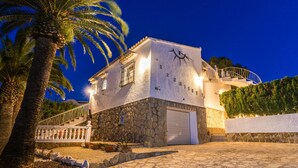 A stone building with a white door and a balcony. - 2 Bedroom Villa in Landscaped Gardens (Javea / Xàbia)