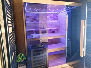 A modern, well-lit room with a glass partition, wooden shelves, and a small table with a plant. - Holiday Home Grofica (Daruvar)