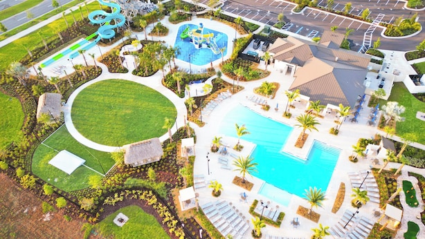 Luftaufnahme eines Resorts mit großem Pool, Wasserpark und Parkplatz.